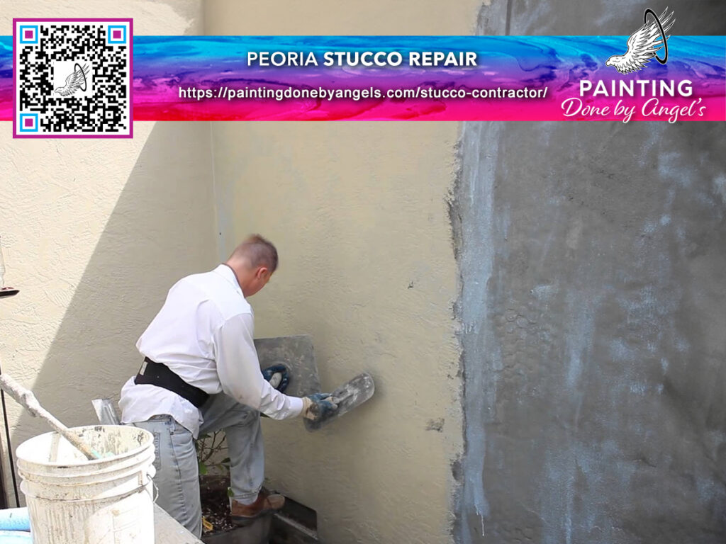 A professional worker from a Painting Company applies stucco to an exterior wall as part of a repair and painting service.