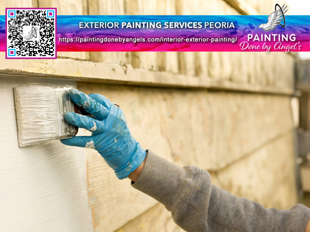 A hand wearing a blue glove applies white paint on exterior wooden siding, with an advertisement for exterior painting services and stucco repair, including a QR code for more information.