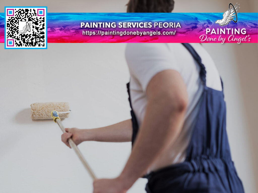 A professional painter in overalls using a roller to apply paint to a wall, with an advertisement for "exterior painting services Peoria - painting done by angel's" alongside a QR code and website