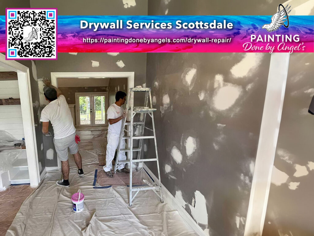 Two professionals from a Painting Company performing drywall repair and preparation for painting in a residential interior space.