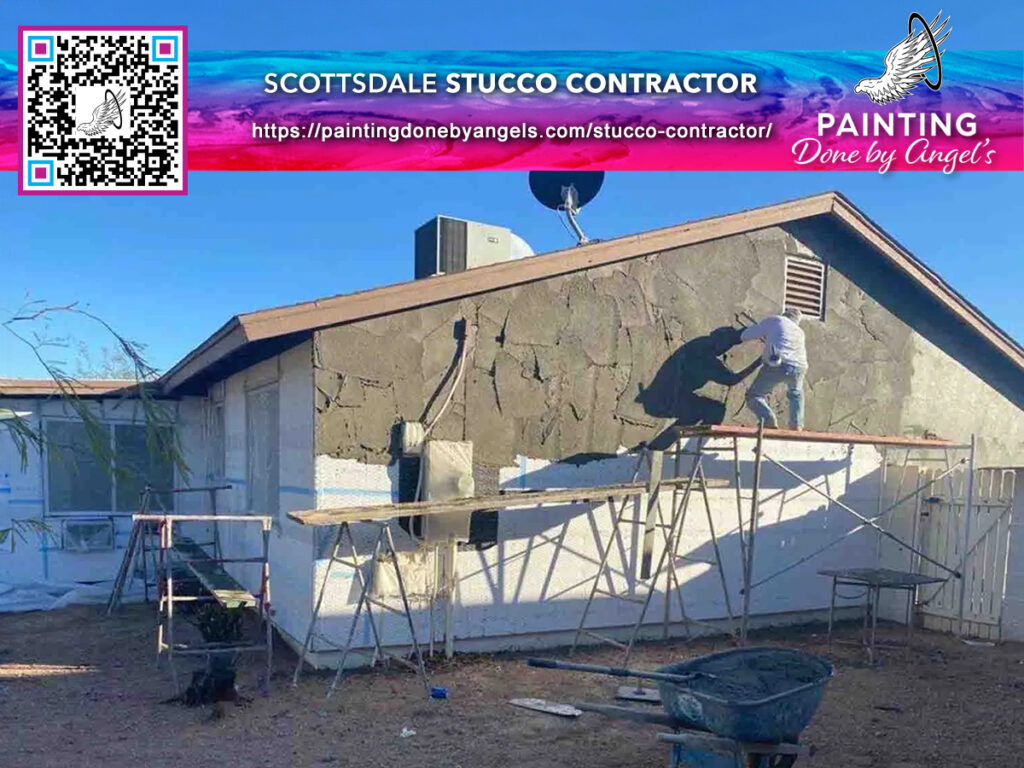 A person applying stucco to the exterior wall of a house with scaffolding set up for the work, with an advertisement for an exterior painting company in Scottsdale displayed in the corner.