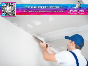Professional painter specializing in interior painting and applying spackle for drywall repair, with business advertising for "painting done by angels" in the background.