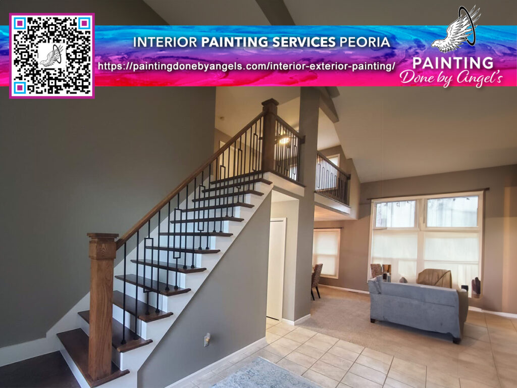 A beautifully painted residential interior featuring an elegant staircase with contrasting dark railings, leading up from a spacious living room with neutral walls, as advertised by a painting services company.