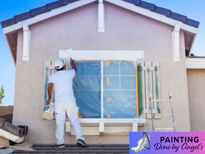 A painter carefully applying a fresh coat of paint to the exterior of a house, with meticulous prep work visible on the window to protect it from paint splatters, showcasing expertise in exterior painting.