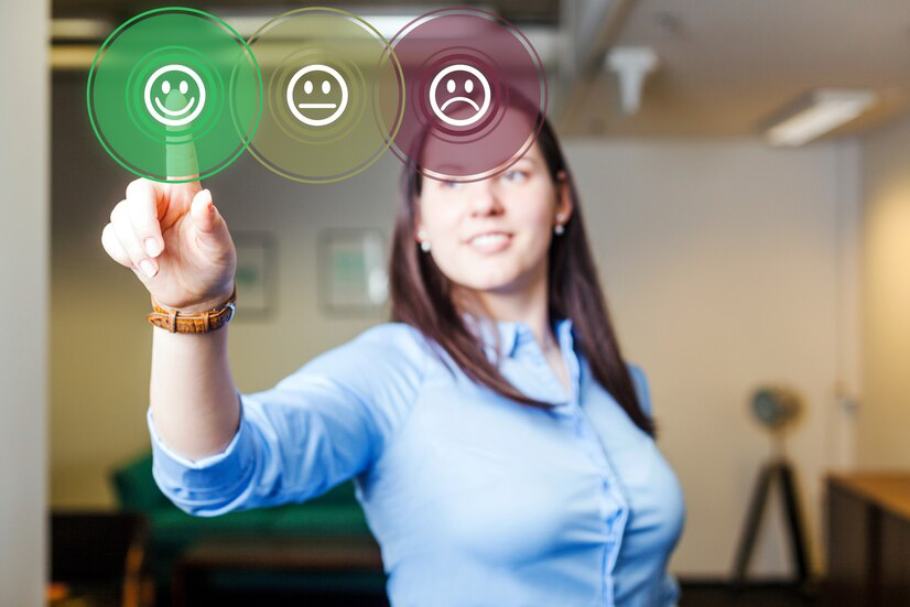 A woman in a business setting touching a virtual feedback interface with smiley faces ranging from happy to unhappy, symbolizing services like Drywall Repair.